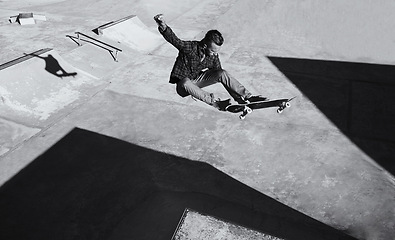 Image showing Man, jump and skateboard at skatepark for training with practice or hobby to play tricks. Monochrome, exercise and experience on break or leisure to enjoy for activity, sport and fitness with passion