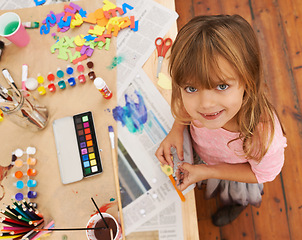 Image showing Happy girl, portrait and drawing with color for creativity, learning or education above. Top view of young child with smile and paintbrush for sketching, writing or artwork in happiness at the house