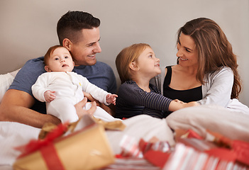 Image showing Love, unboxing and happy family with gift in bed in celebration of birthday, event or mothers day at home together. Support, care and kids with parents in a bedroom with thank you, present or bonding