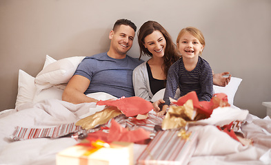 Image showing Love, happy family and gift unboxing in a bed in celebration of birthday, event or mothers day at home together. Support, care and girl with parents in a bedroom with thank you, present or bonding