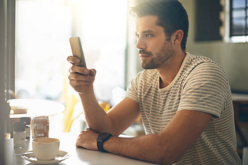 Image showing Man, relax at coffee shop with smartphone and scroll online for social media, tech and communication. Chat, reading on mobile app or ebook with break at cafe, contact and using phone with network