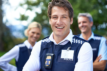 Image showing Security, law enforcement and portrait of happy policeman outdoors for crime, protection and safety service. Teamwork, collaboration and officer with crossed arms for patrol, justice and surveillance