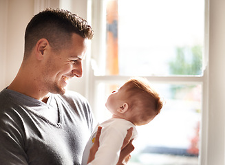 Image showing Father, baby and home with care, love and support together with family bonding, playing and development. Dad, smile and young child in a house with kid and parent happy about infant growth at window