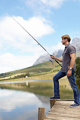 Image showing Fishing, pole and man in nature for travel, break or stress relief at a lake on vacation, holiday or trip. Fish, line and calm male person at outdoor river for water, adventure or peace in a forest