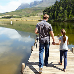 Image showing Father, daughter and holding hands by lake for fishing, vacation or summer with walk on jetty. Dad, man and girl child with bonding, connection and outdoor for adventure, learning or holiday by river