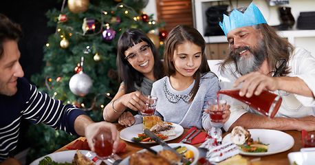 Image showing Christmas, family and parents with child celebrate for dinner, lunch and drinking together for festival. Mother, father and girl with food for holiday, vacation or festive celebration at dining table