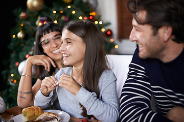 Image showing Christmas, family and happy parents with child in home for dinner, lunch and eating together. Mother, father and girl laughing with food for holiday, vacation and festive celebration at dining table