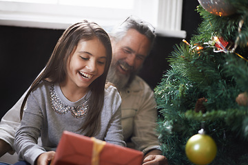 Image showing Grandpa, child and gift by Christmas tree on xmas, festive season and present for bonding in lounge. Grandfather, girl and home for package on religious holiday, celebration and love for tradition