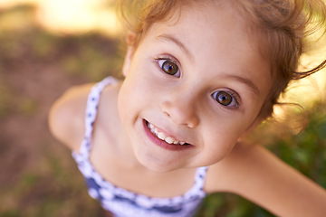 Image showing Girl, child and portrait in park with top view, play games outdoor in nature for childhood and fun with fresh air. Happiness, travel and freedom with youth, public garden or playground with closeup