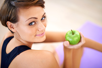 Image showing Portrait, exercise and happy woman with apple in gym for diet, nutrition and wellness with healthy body. Face, fitness and person eating fruit for vitamin c or benefits of organic food on yoga mat