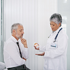 Image showing Hospital, consulting and doctor with patient and pills, medication and prescription in clinic. Healthcare, talk and health worker with senior man for wellness, supplements and medicine for treatment