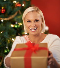 Image showing Christmas, gift and woman giving for holiday surprise, celebration and tradition at night. Excited, happy and young person by tree and bokeh lights with present, box and thanksgiving or love at home
