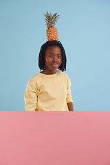 Image showing Portrait, banner or boy child with pineapple in studio for health, wellness or gut health on blue background, Fruit, balance or face of African teen model with organic diet poster, nutrition or detox