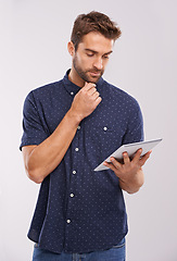 Image showing Business man, studio and online research on tablet with thinking, planning and problem solving for project. Designer, creative idea or touchscreen for fashion prototype or digital by grey background