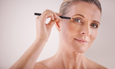 Image showing Cosmetics, portrait and woman with eyeliner in studio for beauty, natural and self care routine. Makeup, senior and female person with cosmetology product for facial treatment by white background.