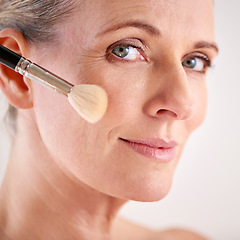 Image showing Brush, makeup and face of woman in studio for cosmetic, self care and facial glow routine. Beauty, foundation and portrait of female person with cosmetology tool for treatment by white background