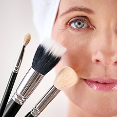 Image showing Portrait, woman and makeup with brushes, closeup and beauty treatment on white studio background. Face, person and model with product and tool with wellness and skincare with cosmetic and dermatology