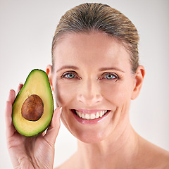 Image showing Skincare, avocado and portrait of mature woman in studio for health, wellness or natural face routine. Smile, beauty and female person with organic fruit for dermatology treatment by white background