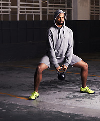 Image showing Bodybuilder, fitness and exercise with kettlebell for training, muscle workout and endurance in parking lot. Man, equipment and serious athlete with power for balance, strength and healthy body