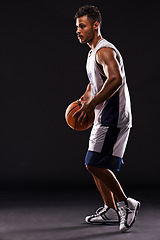 Image showing Man, basketball player and playing game in studio as athlete for workout competition, training or black background. Male person, sports and exercise champion or professional, fitness or mockup space