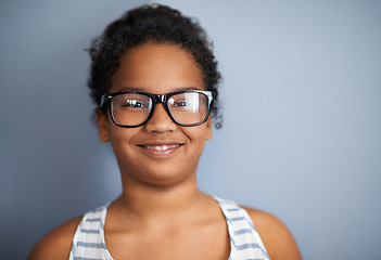Image showing Happy child, girl and portrait in studio with glasses, education and pride in school or academic excellence. Kid, face and smile in prescription eyewear to support learning, eyecare and ophthalmology