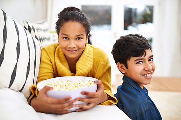 Image showing Happy family, siblings and popcorn in portrait in home and relax or bonding together on weekend. Boy, girl and positive face of teenagers on couch, peace and snack for school holiday in living room