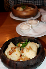 Image showing Varenyky with fried slices of bacon in wooden plate