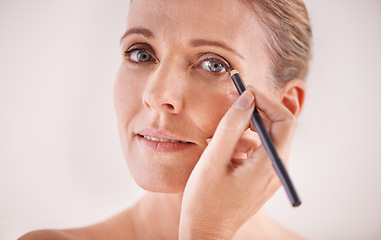 Image showing Makeup, confident and woman with eyeliner in studio for beauty, natural and self care face routine. Cosmetics, portrait and person with cosmetology product for facial treatment by white background.