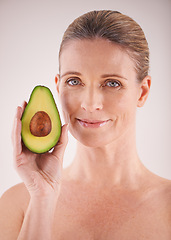 Image showing Skincare, avocado and portrait of woman in studio for health, wellness or natural facial routine. Smile, beauty and mature person with organic fruit for face dermatology treatment by gray background.