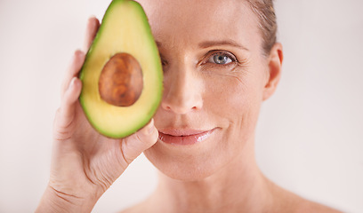 Image showing Cosmetic, avocado and portrait of woman in studio for health, wellness or natural facial routine. Skincare, beauty and mature person with organic fruit for dermatology treatment by white background.