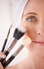 Image showing Portrait, mature woman or makeup with brushes, closeup or dermatology on grey studio background. Face, person or model with product or tool with wellness or skincare with beauty treatment or grooming