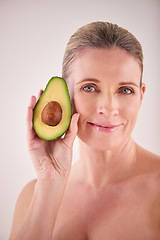 Image showing Beauty, avocado and portrait of mature woman in studio for health, wellness or natural face routine. Smile, skincare and female person with organic fruit for dermatology treatment by white background