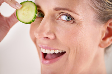 Image showing Skincare, cucumber and portrait of mature woman in studio for health, wellness or natural routine. Smile, beauty and female person with organic vegetable for dermatology treatment by gray background.