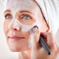 Image showing Mature woman, face mask and brush with happiness in studio for skincare or anti aging on self care, wellness and fresh skin. Closeup, female person and glow with smile for facial and beauty or luxury