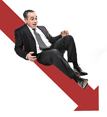 Image showing Businessman sliding down red arrow