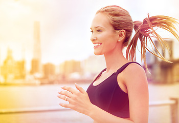 Image showing Woman, athlete and running for fitness in city, jogging active and or happy female person exercising in New York. Energy, marathon for sports training or workout, cardio for endurance wellness