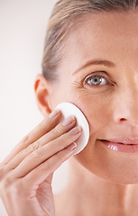 Image showing Mature woman, portrait and cotton for skincare in studio with facial cleansing, cosmetics or skin treatment. Model, person or swab for face detox, makeup removal or natural beauty on white background