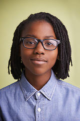 Image showing African teenager, glasses and portrait in studio for education, learning and knowledge on a green background. Face of happy, creative and smart child, boy or student with vision for school in studio
