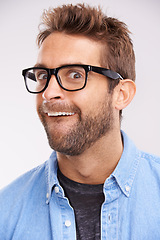 Image showing Silly face, nerd and man with glasses, portrait and goofy guy on a grey studio background. Model, eyewear and person with facial expression and reaction with mindset and happiness with comedy or joke