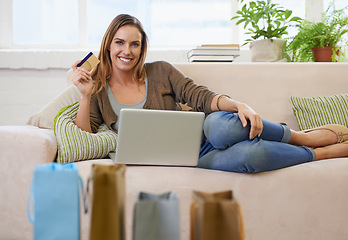 Image showing Woman, portrait and credit card with laptop for fashion or online shopping in apartment for ecommerce, banking or payment. Female person, face and couch for web finance or tech, budget or investment