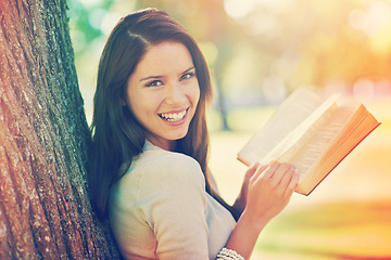 Image showing Tree, portrait and girl with novel to relax, book and fiction in nature of park outdoor. Adult, woman and female person with confidence for knowledge, happy and joy for reading in summer garden