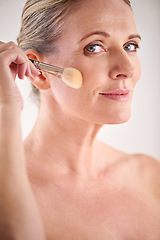 Image showing Brush, cosmetic and portrait of woman in studio for makeup, self care and facial glow routine. Beauty, foundation and mature female person with cosmetology tool for face treatment by white background