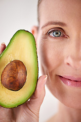 Image showing Skincare, avocado and closeup face of woman in studio for health, wellness or natural facial routine. Smile, beauty and mature person with organic fruit for dermatology treatment by white background.