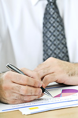 Image showing Office worker writing on reports