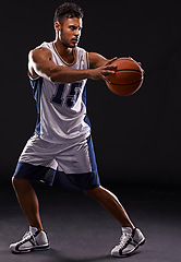 Image showing Man, basketball player and sports game in studio as athlete for workout competition, training or black background. Male person, pass and exercise champion for professional, fitness or mockup space