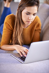 Image showing Relax, home and woman with a laptop, typing and connection with internet in a living room. Person on couch, apartment and girl with a computer and research with website information, tech and network