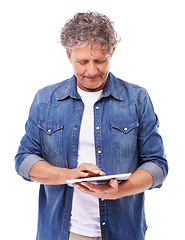 Image showing Tablet, typing and senior man in studio networking on social media, app or internet for communication. Research, browsing and elderly male person scroll on digital technology by white background.