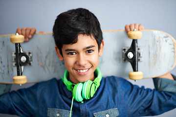 Image showing Portrait, happy and boy with skateboard, headphones and recreation with music and cheerful. Kid, face or childhood with skater or headset with joy or hobby with smile, casual or gen z with confidence