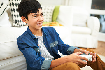 Image showing Living room, play and video games for boy with smile, fun and joy to relax on floor with technology. Lounge, preteen and kid with happiness in apartment, home and gamer with controller or gamepad