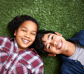 Image showing Children, brother and sister on grass, above and portrait with smile, bonding and relax in backyard at family home. Kids, boy and girl siblings with care, love and connection on vacation in spring